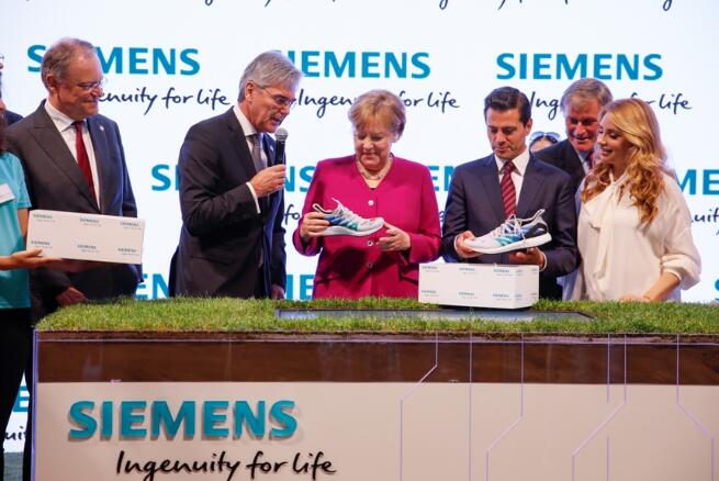 西门子股份公司总裁兼首席执行官凯飒（Joe Kaeser）向德国总理默克尔和墨西哥培尼亚赠送运用西门子技术制造的运动鞋