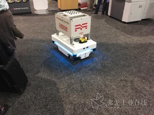 图2 自主车辆正在穿过人头攒动的贸易展，将部件从机器人照管的机器送至机器人照管的检查岗位。在生产工厂里，它也可以完成相同任务